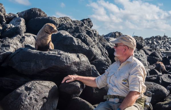 Man getting a close look at a sea lion pup.